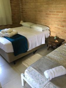 a bedroom with two beds and a table with towels at Casinha na Represa 1 in CÃ¡ssia