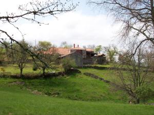 een oud huis op een groen veld bij Caserío da Castiñeira in Sas do Monte