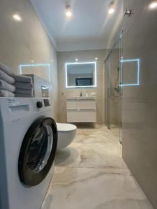 uma casa de banho com uma máquina de lavar roupa e um WC em Copernicus Sky Apartment em Zielona Góra