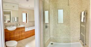 ein Badezimmer mit einer Badewanne, einem Waschbecken und einem WC in der Unterkunft Roseberry House in Newcastle Emlyn