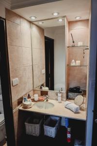 uma casa de banho com um lavatório e um espelho grande em Sarmiento Suites Premium em Salta