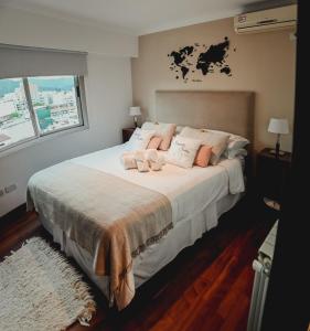 薩爾塔的住宿－Sarmiento Suites Premium，卧室配有带粉红色枕头的大型白色床