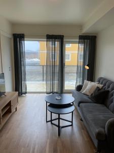 sala de estar con sofá y mesa en Helt ny leilighet, en Leknes