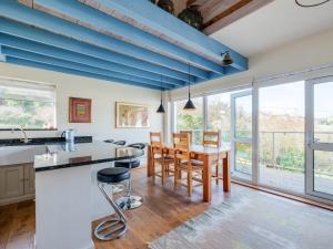 a kitchen with blue ceilings and a table and chairs at Beachside in Polzeath