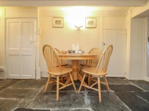 a dining room with a wooden table and chairs at 2 Rose Cottages in Looe +11 photos