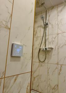 a shower with a shower head in a bathroom at Veski Apartment in Kuressaare