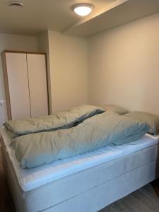 uma cama num pequeno quarto com em Helt ny leilighet em Leknes