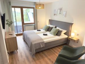 a bedroom with a large bed and a chair at Seehaus Aachblick, Stilvolle Apartments und Ferienwohnungen in Uhldingen-Mühlhofen