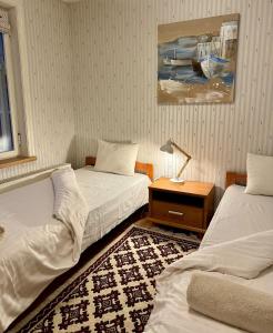 a bedroom with two beds and a table with a lamp at Veski Apartment in Kuressaare