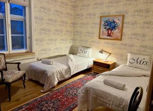a bedroom with two beds and a chair and a rug at Veski Apartment in Kuressaare