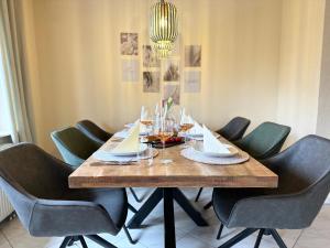 a dining room table with chairs and wine glasses at Seehaus Aachblick, Stilvolle Apartments und Ferienwohnungen in Uhldingen-Mühlhofen +35 photos