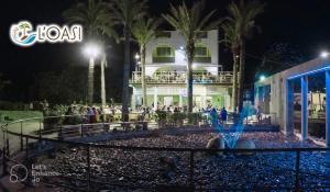 a crowd of people standing in front of a building at night at HOTEL - B&B - RISTORANTE L'Oasi in Metaponto