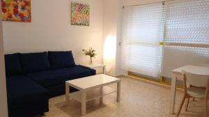- un salon avec un canapé bleu et une table dans l'établissement Navegante, à El Puerto de Santa María