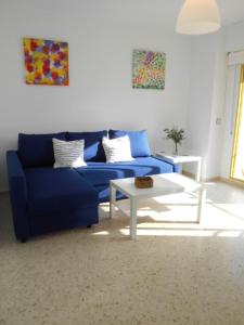 sala de estar con sofá azul y mesa en Navegante, en El Puerto de Santa María