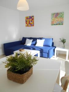 sala de estar con sofá azul y mesa en Navegante, en El Puerto de Santa María