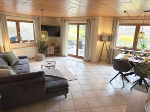 a living room with a couch and a table at Seehaus Aachblick, Stilvolle Apartments und Ferienwohnungen in Uhldingen-Mühlhofen