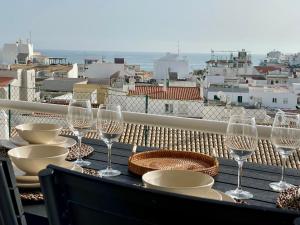 a table with wine glasses and plates on a balcony at RosaMar in Albufeira