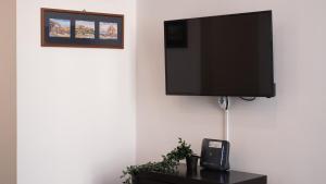 TV de pantalla plana colgada en la pared en Casa Latilla, en Nápoles