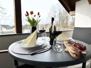 a table with a plate of food and a bottle of wine at Seehaus Aachblick, Stilvolle Apartments und Ferienwohnungen in Uhldingen-Mühlhofen