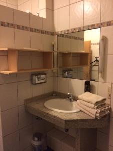 a bathroom with a sink and a mirror and towels at Hotel Am Salzberg in Philippsthal