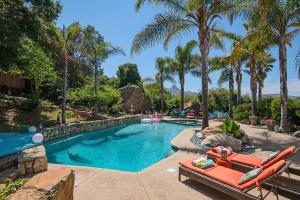 uma piscina com palmeiras e um resort em The Malibu Retreat Private Compound w/ Salt Water Pool + Views em Malibu