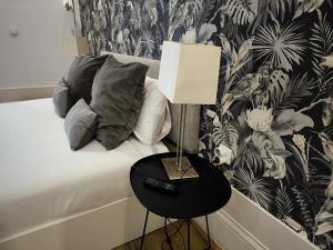 a bed with a side table with a lamp on it at Citybreak-apartments Lapa in Porto