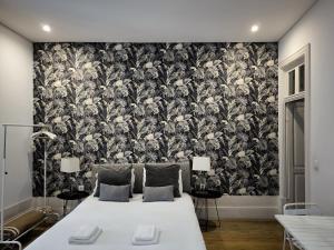 Citybreak-apartments Lapa في بورتو: غرفة نوم مع سرير وورق جدران من اللون الأسود والأبيض