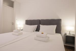 um quarto com uma cama branca e toalhas em Goldberg Apartments Osijek em Osijek
