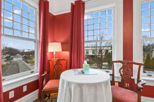 斯普林菲爾德的住宿－The Pasfield House，红色的房间,配有桌子和两把椅子,并设有一个窗口