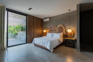 ein Schlafzimmer mit einem großen Bett und einem großen Fenster in der Unterkunft Hotel Poblado Park in Medellín
