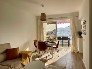 a living room with a couch and a table with chairs at RosaMar apartment sea view and pool in Albufeira