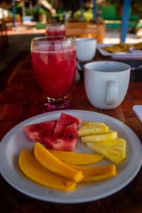 a plate of fruit and a drink on a table at Isla Los Erizos EcoHouse in Isla Grande