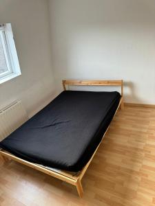 Bett in einem Zimmer mit schwarzer Matratze in der Unterkunft Maison familiale Lille in Lille