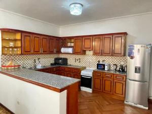 a kitchen with wooden cabinets and a refrigerator at METRO Deluxe Specious Home in a Great Neighborhood!! in Addis Ababa