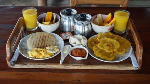 a tray of food on a table with orange juice at Isla Los Erizos EcoHouse in Isla Grande