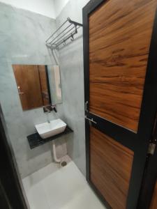 a bathroom with a sink and a wooden door at The prime hotel in Ujjain