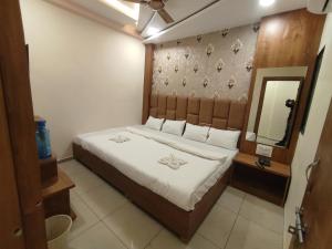 1 dormitorio con 1 cama grande y espejo en The prime hotel, en Ujjain