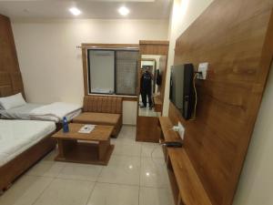 Habitación pequeña con cama y TV. en The prime hotel en Ujjain