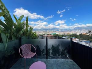einen Balkon mit Stühlen und Stadtblick in der Unterkunft Hotel Poblado Park in Medellín