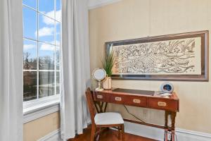 una scrivania con specchio e sedia accanto a una finestra di The Pasfield House a Springfield