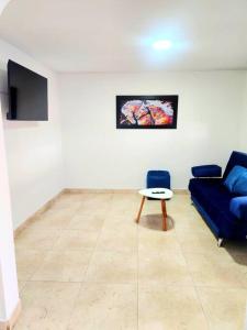 sala de estar con sofá azul y mesa en Casa Cerca del Aeropuerto: Spa con Sauna y Jacuzzi, en Bogotá