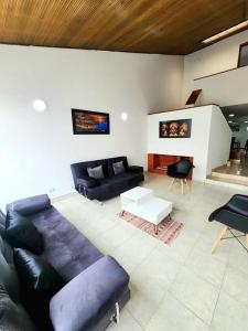 sala de estar con sofá púrpura y chimenea en Casa Cerca del Aeropuerto: Spa con Sauna y Jacuzzi, en Bogotá