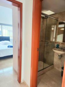 a bathroom with a shower and a sink and a bed at Casa Cerca del Aeropuerto: Spa con Sauna y Jacuzzi in Bogotá