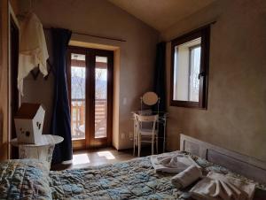 1 dormitorio con cama, mesa y ventana en Sasso Erminia R&B Ecosostenibile en Novafeltria