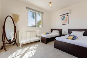 a bedroom with two beds and a mirror at Villa Lynn Chill Out Seaview in Ayia Napa +47 photos