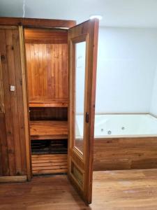 a wooden cabinet with a bath tub in a room at Casa Cerca del Aeropuerto: Spa con Sauna y Jacuzzi in Bogotá