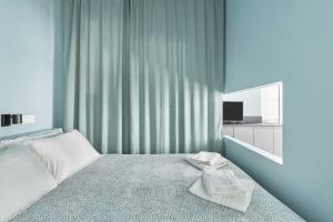 Un pequeño dormitorio con una cama con toallas. en UP to home - Residenze Milano, en Milán