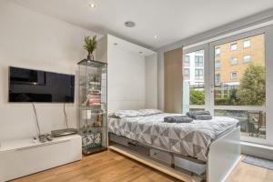 倫敦的住宿－Modern Chíc Studio Chelsea，一间卧室设有一张床和一个大窗户