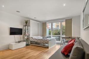 倫敦的住宿－Modern Chíc Studio Chelsea，客厅配有床和沙发