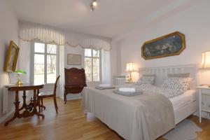 een slaapkamer met een bed, een bureau en ramen bij Młyn Karpnicki - Fischbacher Muehle in Karpniki